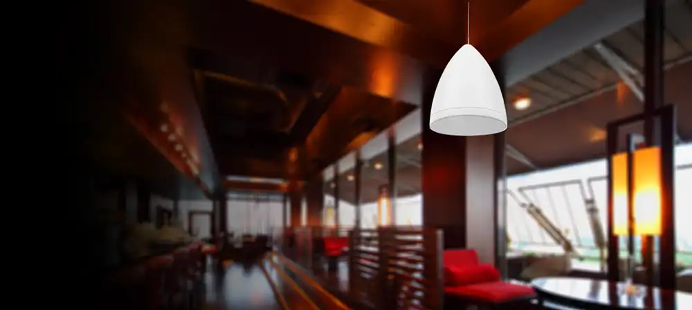 A white pendant light hangs from a ceiling in a Chicago North Shore restaurant.