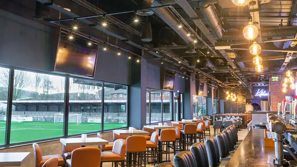 The interior of a sports bar with a view of a soccer field in the Chicago North Shore area.