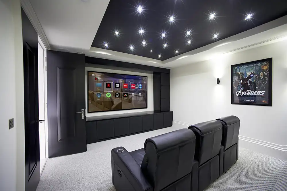 A home theater with a black leather couch and tv in a Chicago North Shore house.