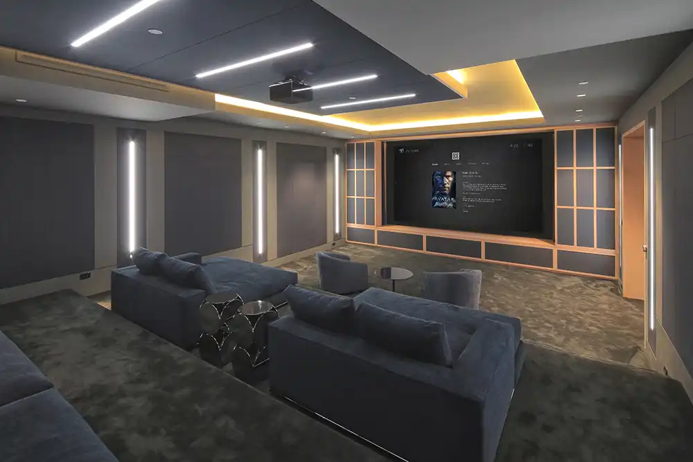 A home theater room with couches and a tv in a Chicago North Shore luxury home.