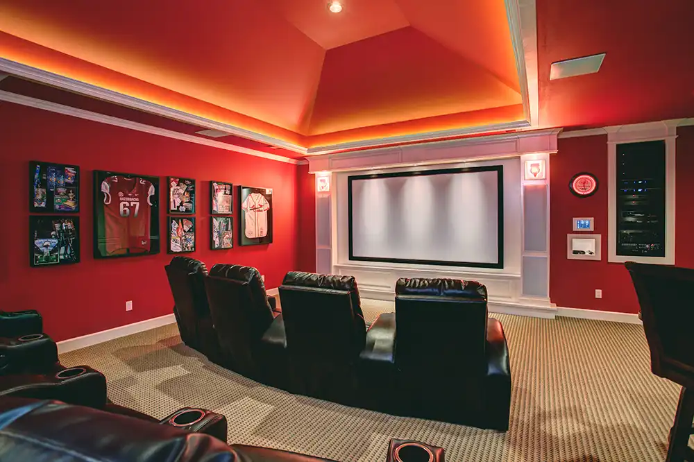 A home theater with red walls and leather seating in a Chicago North Shore luxury home.