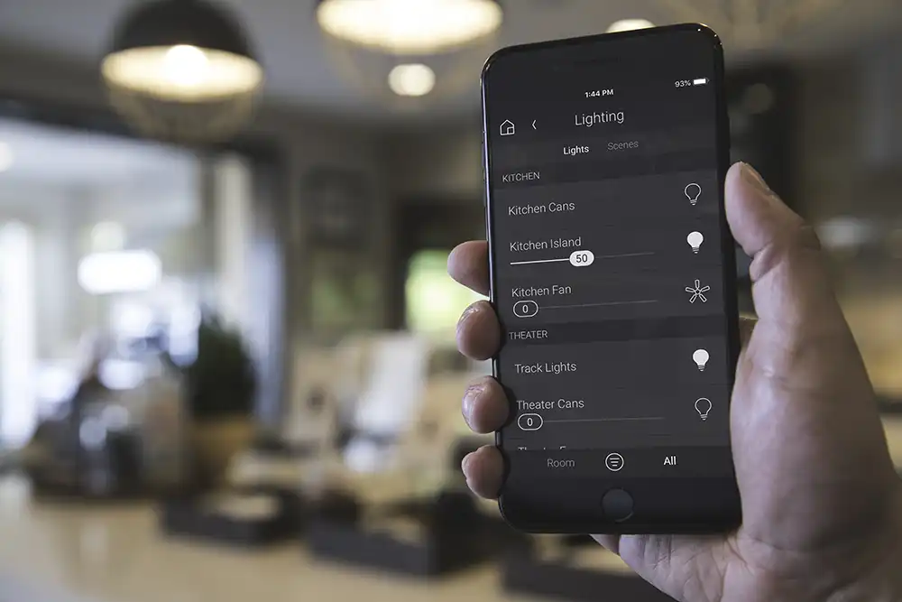 A person holding up a smart phone app that controls the lighting of their Chicago North Shore luxury home.