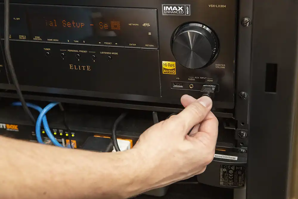 An audiovisual equipment installer adjusting an audio device on a receiver in a Chicago North Shore luxury home.