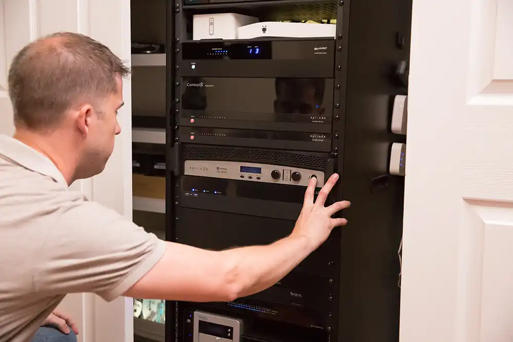 A man looking at an audio system in a closet of a Chicago North Shore home.