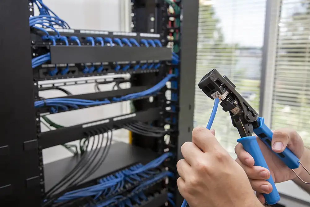 A person is holding a pair of wire cutters in front of a rack of wires in a Chicago North Shore office.