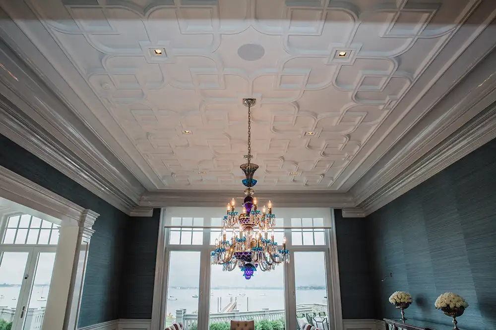 A dining room with smart lighting in a chandelier and blue walls in a Chicago North Shore house.