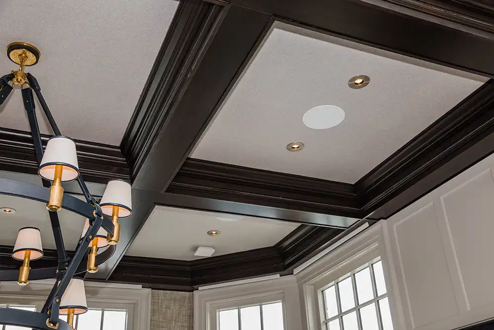 A dining room ceiling with a chandelier and wooden beam treatment in a Chicago North Shore home.