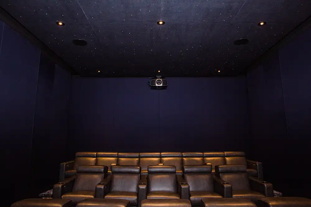 A home theater with leather seats and a dark ceiling in a Chicago North Shore home.