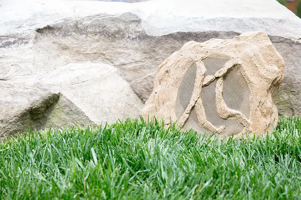 A speaker that looks like a rock in the grass of a Chicago North Shore home.