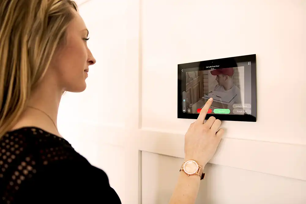 A woman is using a touch screen on a wall of a Chicago North Shore home.